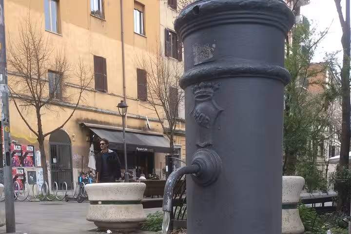 Charming street scene in Rome's Pigneto with a vintage fountain, perfect for a craft beer tour ambiance.