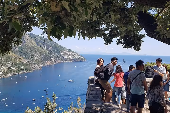 Travelers at coastal viewpoint above Positano, panoramic Amalfi Coast scenery on full-day guided tour from Rome