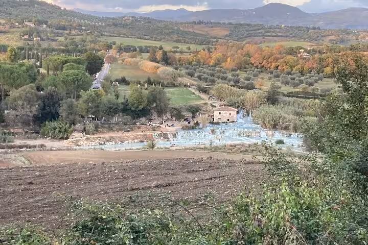 Breathtaking aerial view of Terme di Saturnia's thermal springs surrounded by lush Tuscan landscape.