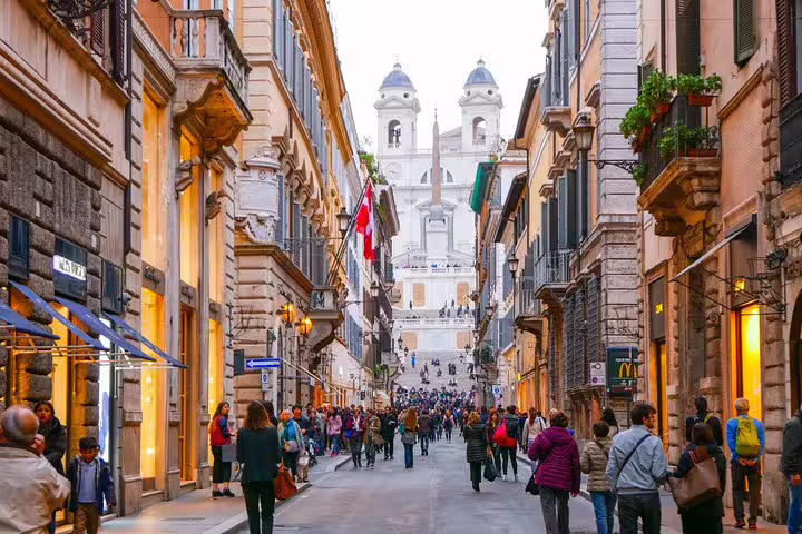 Busy Via dei Condotti leading to the Spanish Steps in Rome, lined with designer boutiques for an exclusive shopping tour