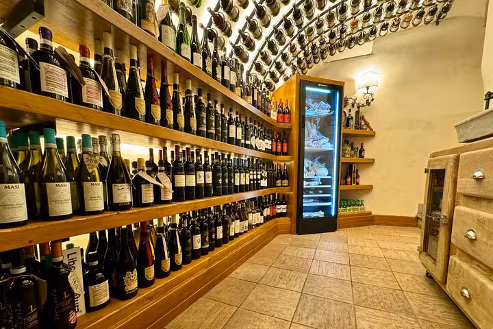 Cozy Roman wine cellar lined with Italian bottles, featured on an exclusive private tour with gourmet food pairing and tastings