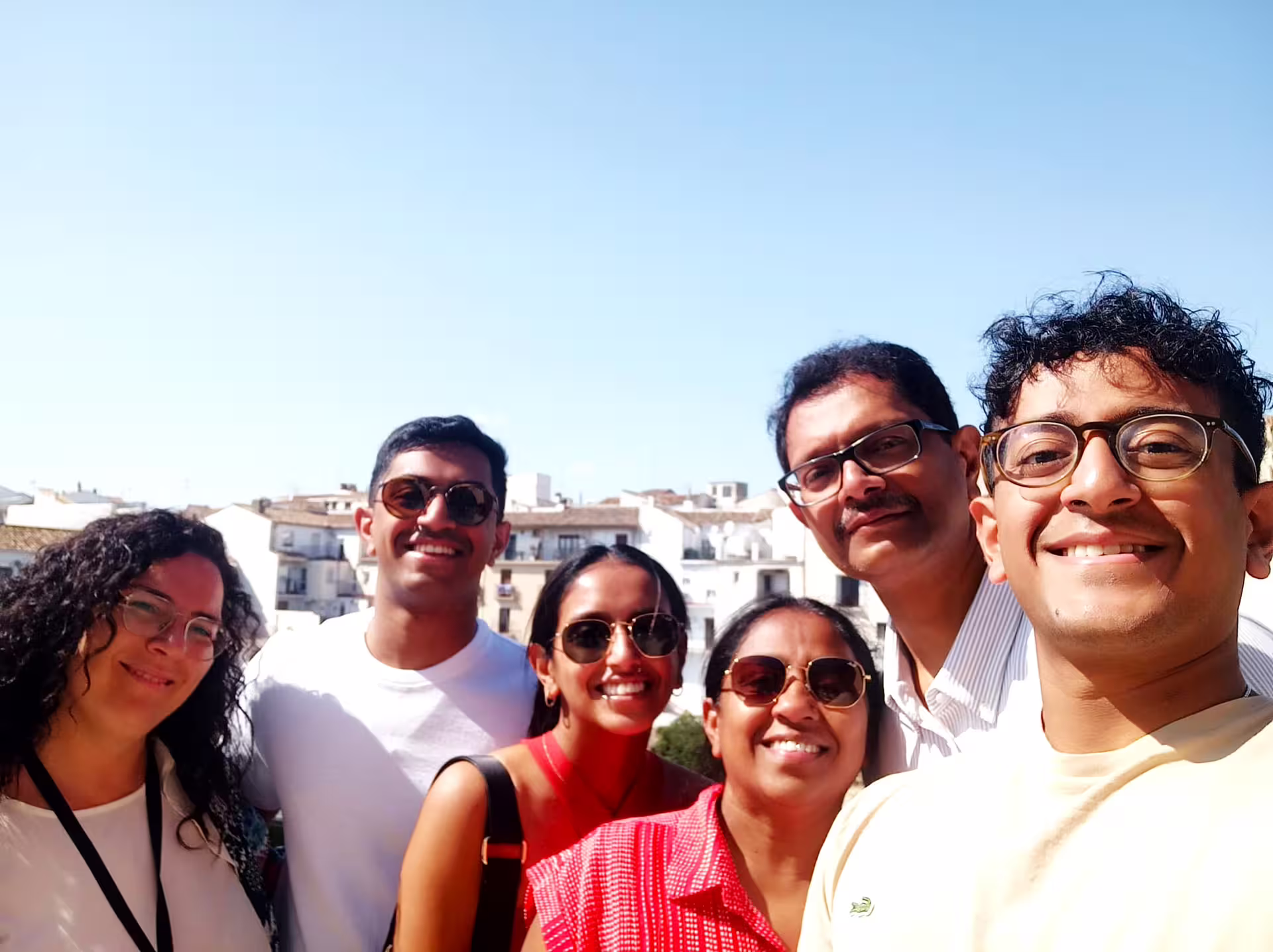 Happy travelers selfie on a Ronda group walking tour, with whitewashed old town rooftops in the background