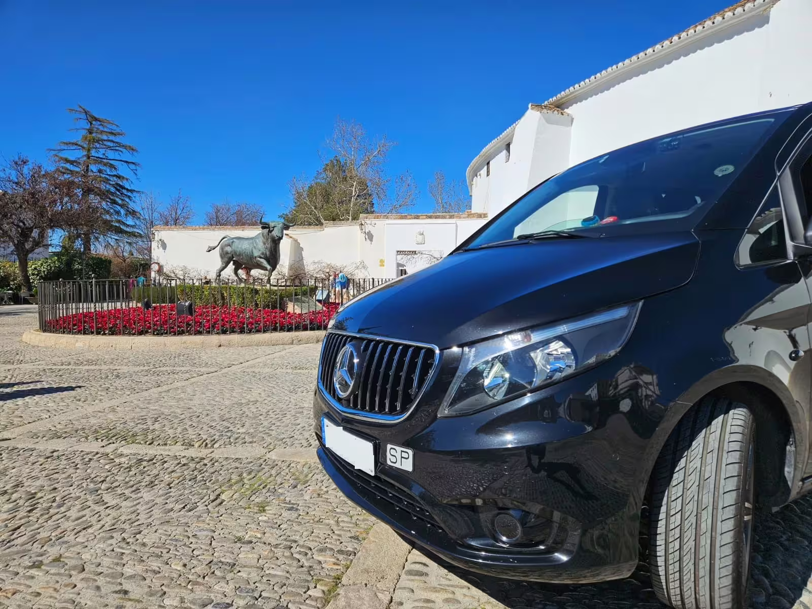 Private Ronda and Marbella day trip with hotel pick-up, luxury minivan in Marbella plaza by bull statue