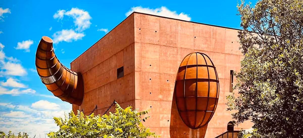 Close-up of a unique architectural feature at Ronda Olive Oil Experience under a bright blue sky.