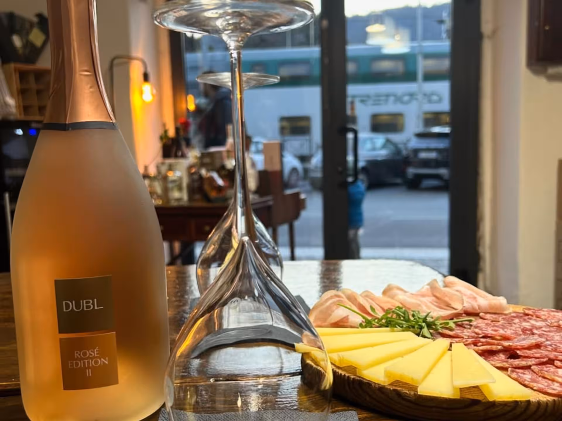 Rosé wine bottle with charcuterie and cheese platter at a Lake Como wine tasting session.