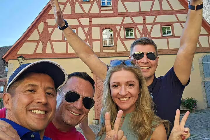 Friends celebrate on Rothenburg scavenger hunt tour, selfie by half-timbered house in Old Town