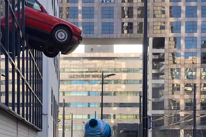 Surreal street art of a red car on a building in Rotterdam, featured on the Future Walking Tour