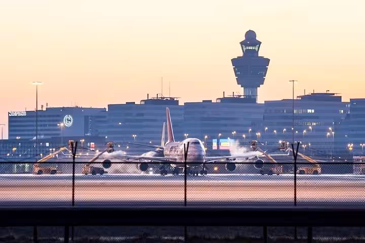 Plane at Amsterdam Schiphol Airport at sunset, perfect for Rotterdam to Schiphol private car transfer