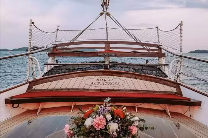 Luxurious deck of the Royal Albatross with flower arrangement, set for a dog-friendly international breakfast cruise.