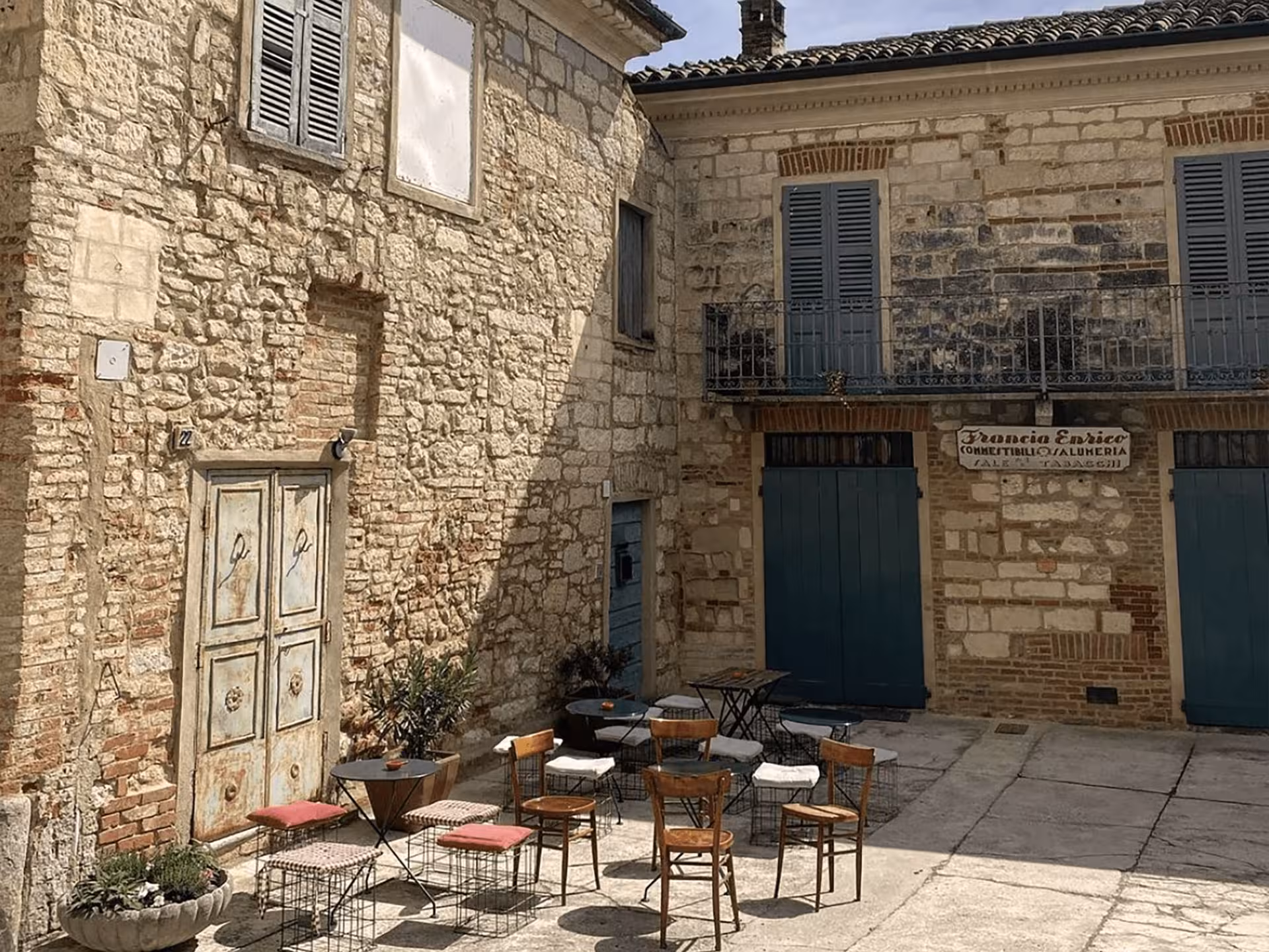 Charming rustic courtyard with vintage chairs and tables, perfect for outdoor wine tasting near Asti.