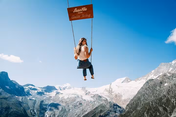 Traveler on Saas-Fee Glacier Swing with panoramic Swiss Alps views on a 4-day trekking tour adventure