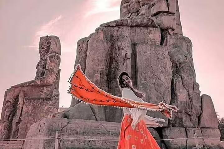 Traveler posing by the Colossi of Memnon at sunset, a highlight of the Safaga Port to Luxor private tour