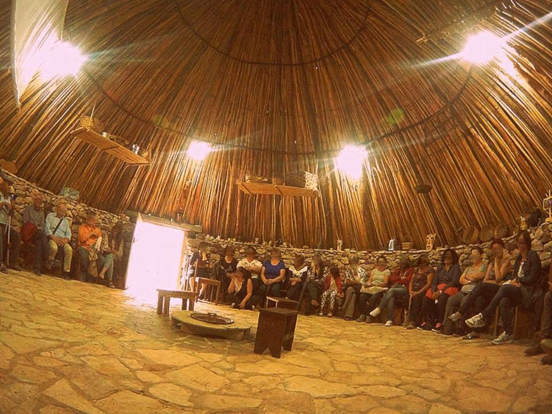 Visitors seated in a traditional Olmedo workshop during a saffron tour, under a wooden dome ceiling.