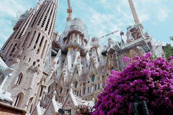 Majestic Sagrada Familia with intricate architecture and vibrant flowers, showcasing Barcelona's iconic landmark.