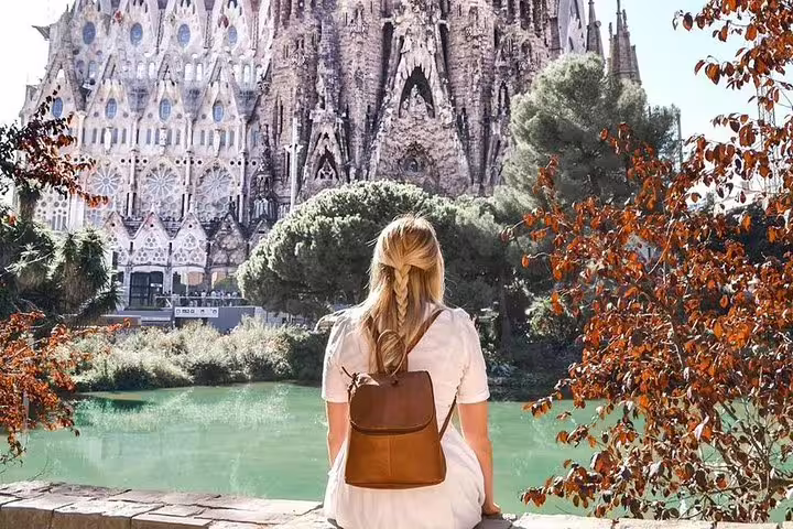 A visitor enjoys a stunning view of the Sagrada Familia from a park, highlighting the architectural marvel on a private Gaudi tour.