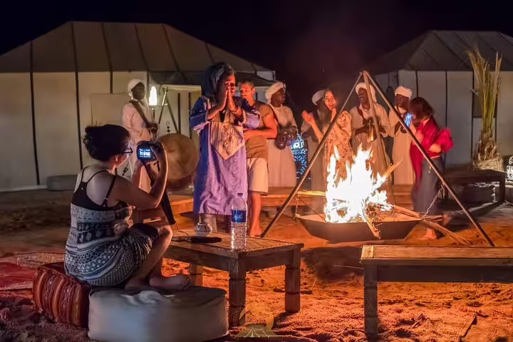 Sahara desert camp bonfire in Merzouga on Morocco 9 days tour from Marrakech with Berber music and tents