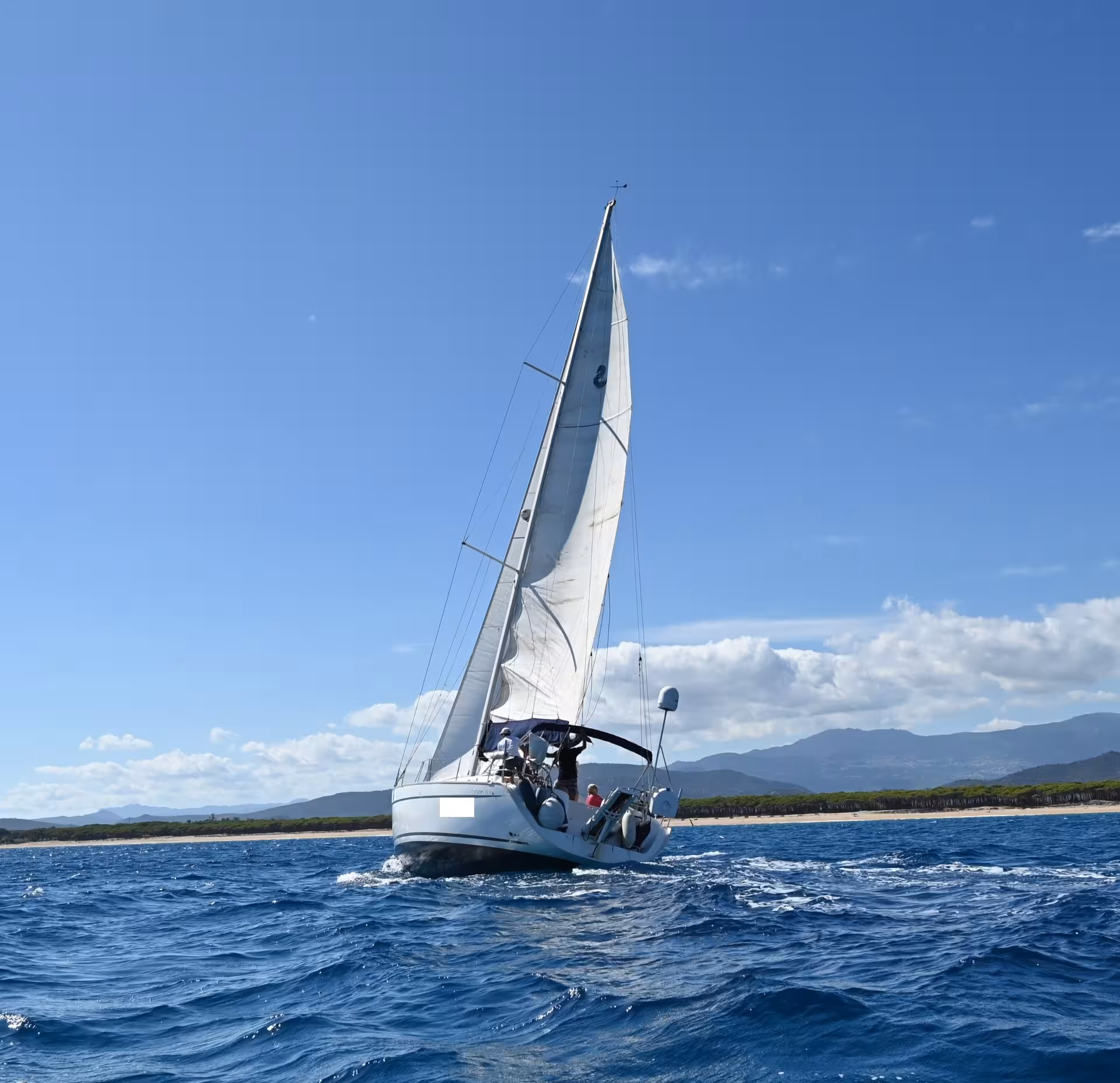Sailboat navigating the Gulf of Orosei with stunning coastal views.