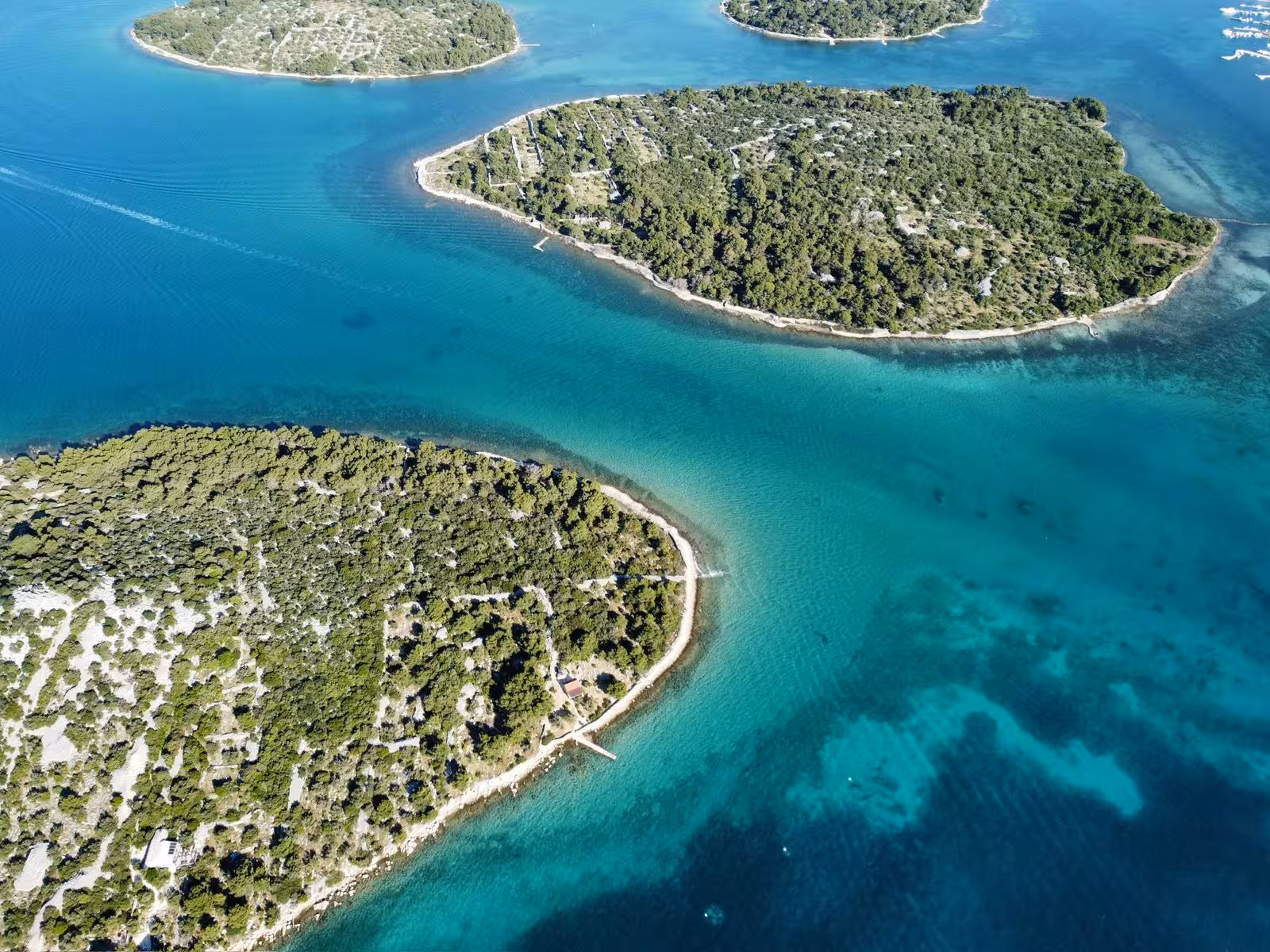 Aerial view of pine-covered islands and turquoise channels, perfect for a Sailing Adventure island-hopping cruise