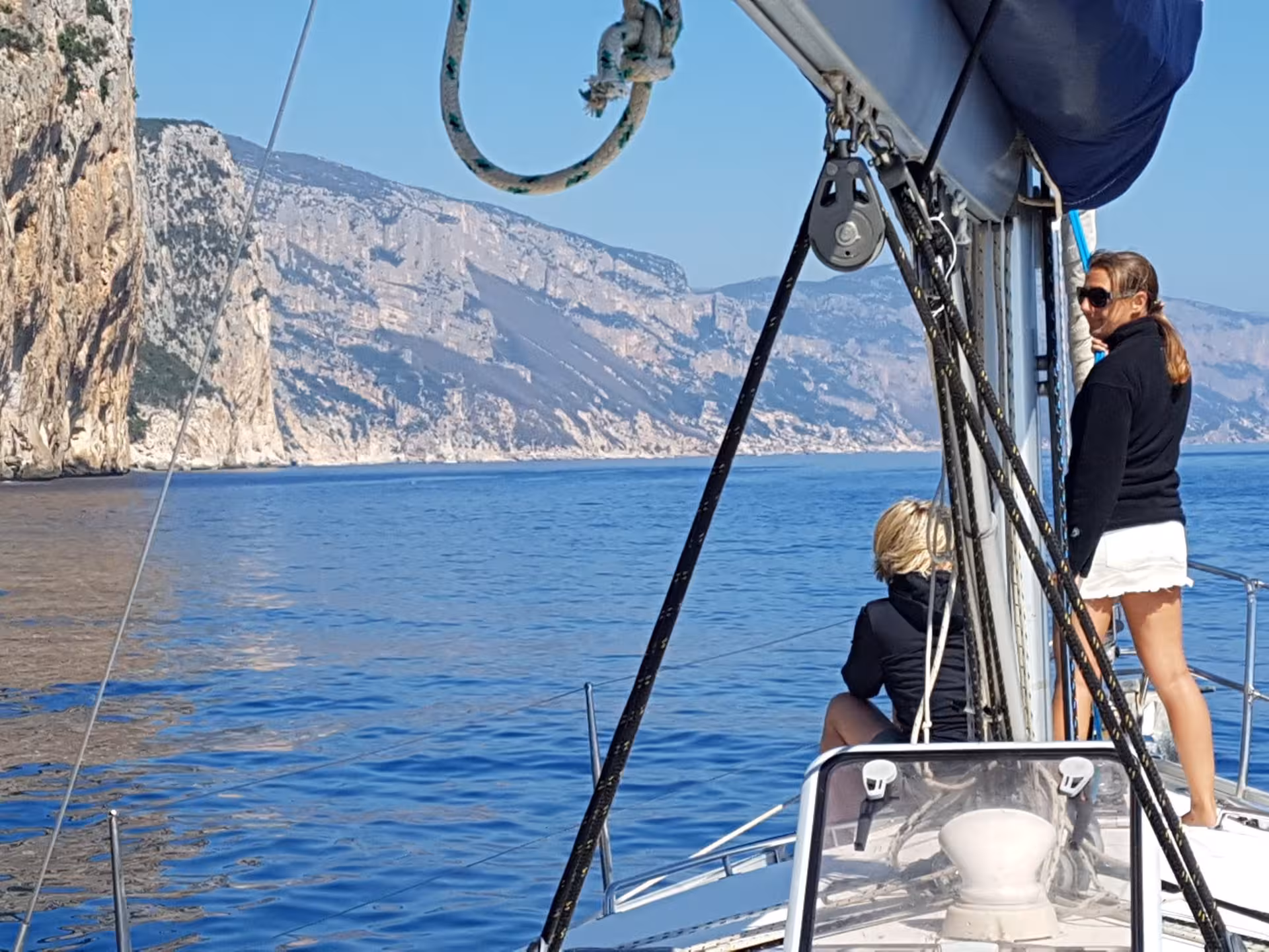 Sailing boat with tourists exploring the stunning cliffs of the Gulf of Orosei near Arbatax, Sardinia.