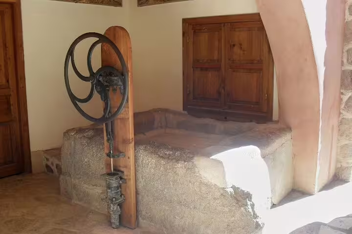 Inside Saint Catherine Monastery on Dahab tour, historic stone well and traditional pulley wheel in courtyard