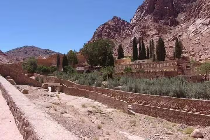 Panoramic view of Saint Catherine’s Monastery gardens beneath Sinai mountains on day trip from Sharm El Sheikh