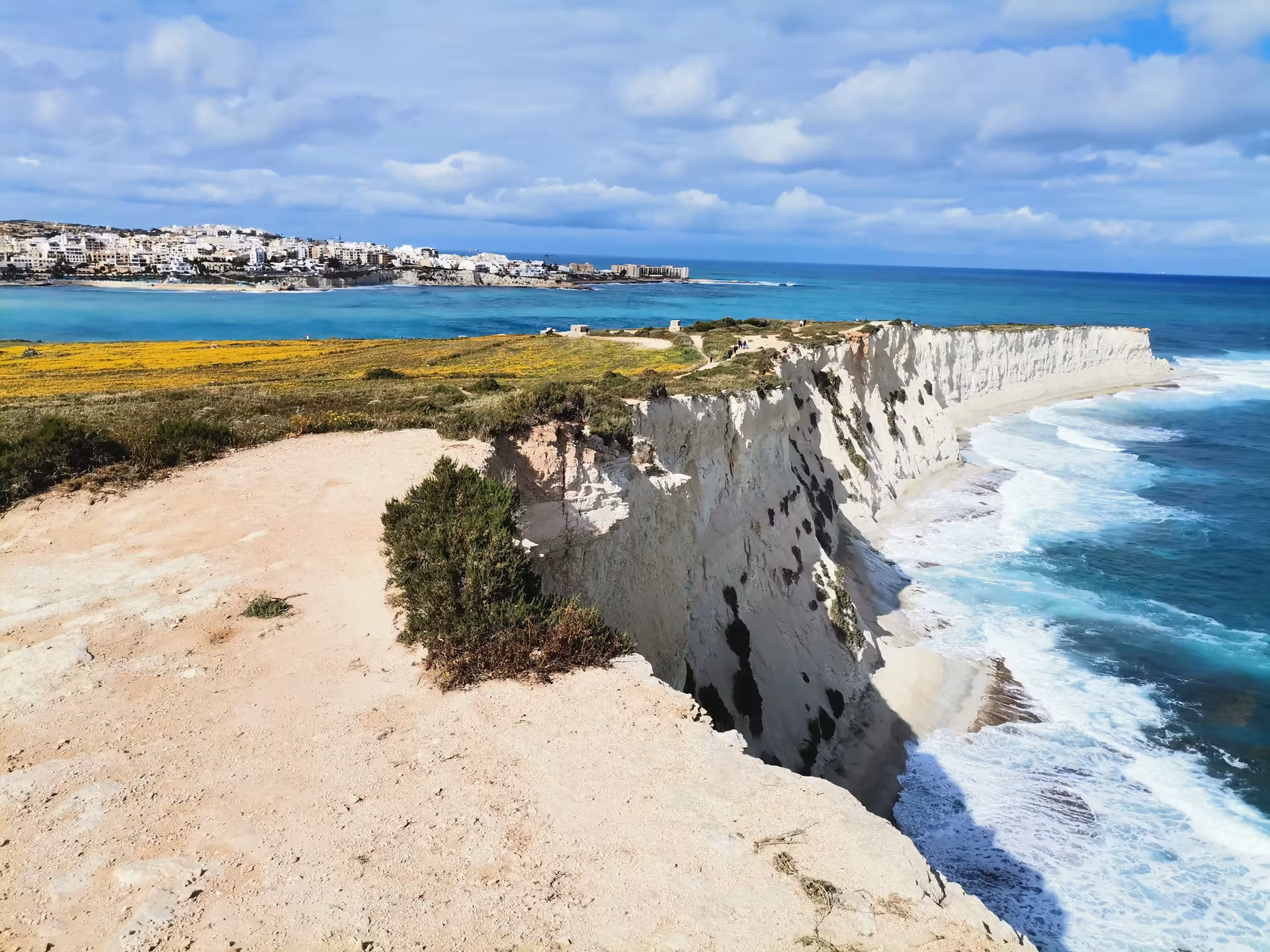 Panoramic white cliffs and turquoise sea near Saint Pauls Bay, Malta, on guided hike with local picnic stop