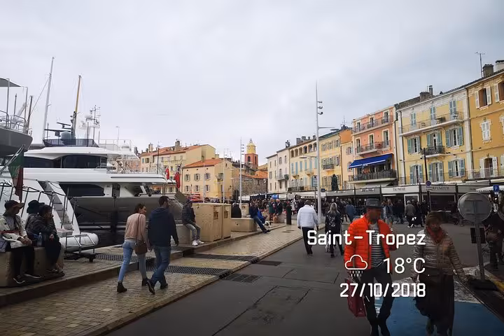 Saint-Tropez old port promenade with yachts and pastel buildings, day trip tour from Bormes-les-Mimosas