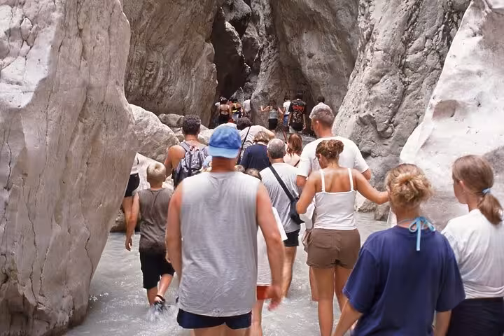 Tourists wade through the narrow waters of Saklıkent Canyon during a private guided tour from Fethiye.