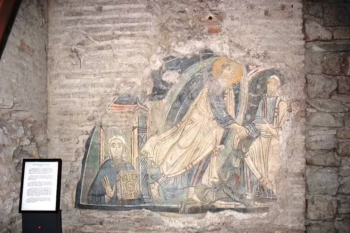 Medieval wall fresco in the subterranean ruins of San Clemente Basilica, explored on a Rome underground private tour