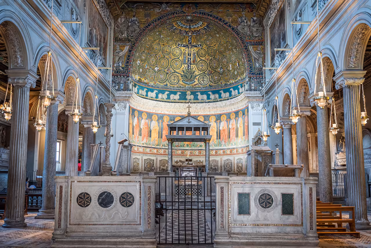 Stunning interior view of San Clemente Basilica in Rome with intricate mosaics and grand arches.