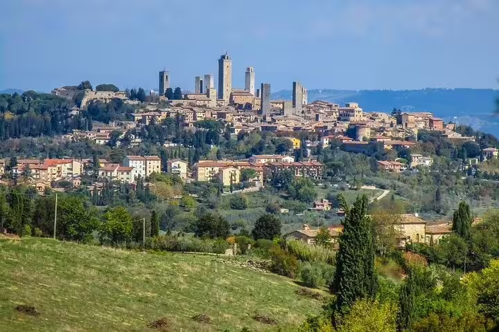 Panoramic view of San Gimignano hilltop towers rising above Chianti countryside vineyards on a half-day Tuscany wine tour