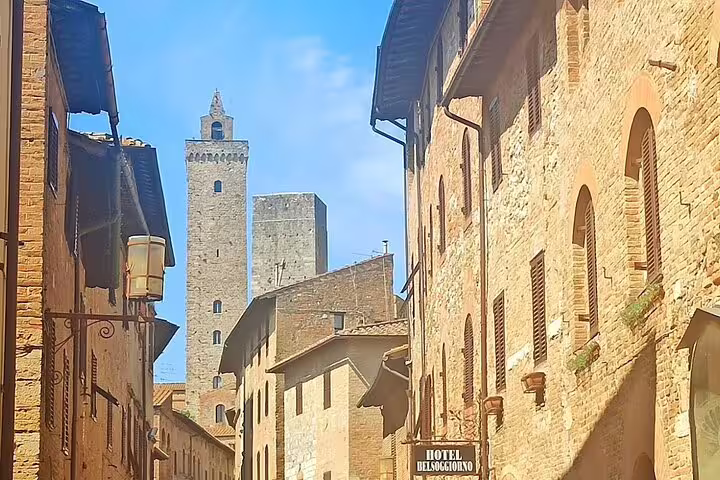 Medieval stone towers and narrow cobbled street of San Gimignano visited on a half-day Chianti Classico wine experience