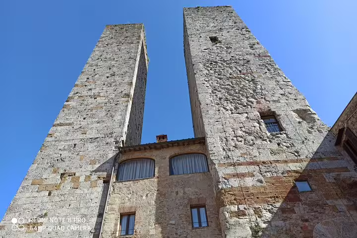 Medieval stone towers of San Gimignano rising against a clear blue sky on a Chianti Classico half-day wine tour