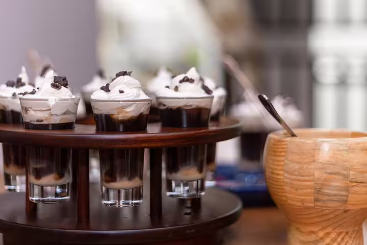 Exquisite dessert shots topped with cream and chocolate chips, served on the San Jose By Night farm-to-table dinner.