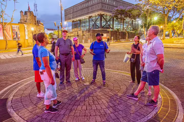 A group of tourists gathers in San Jose's vibrant plaza during the evening for the San Jose By Night tour.