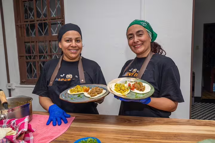 Chefs presenting traditional Costa Rican dishes during a farm-to-table dinner on the San Jose By Night tour.