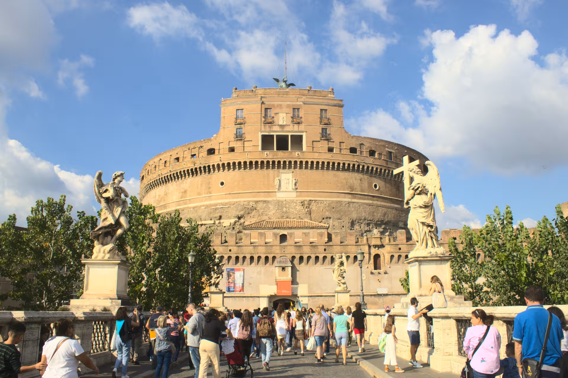 Tourists visiting Sant'Angelo Castle on a sunny day, ideal for exploring Rome's historical sites.