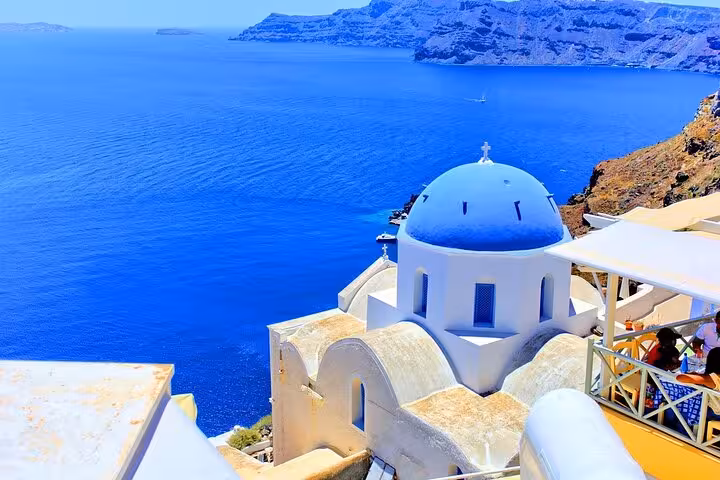 Blue-domed church overlooking Santorini caldera and Aegean Sea, scenic viewpoint on private SUV hidden gems tour