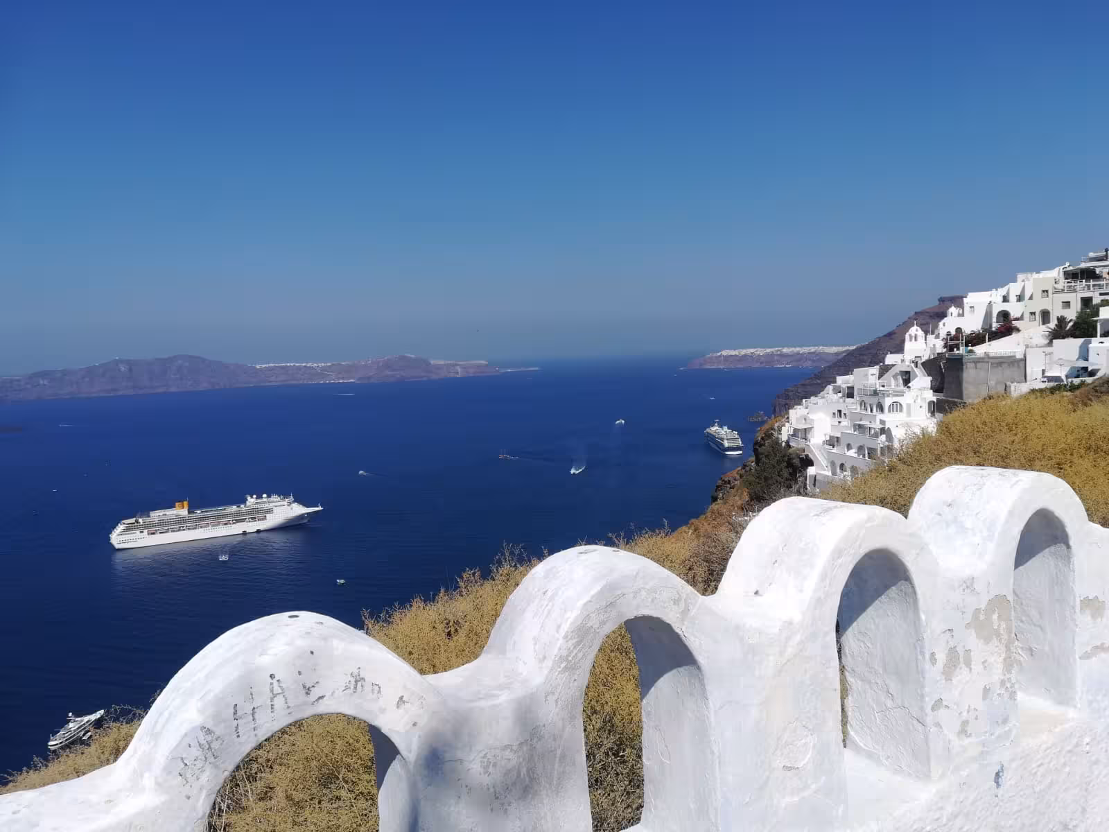 Santorini caldera panorama with cruise ships and cliffside homes, highlight of 4-hour shore-to-Oia tour