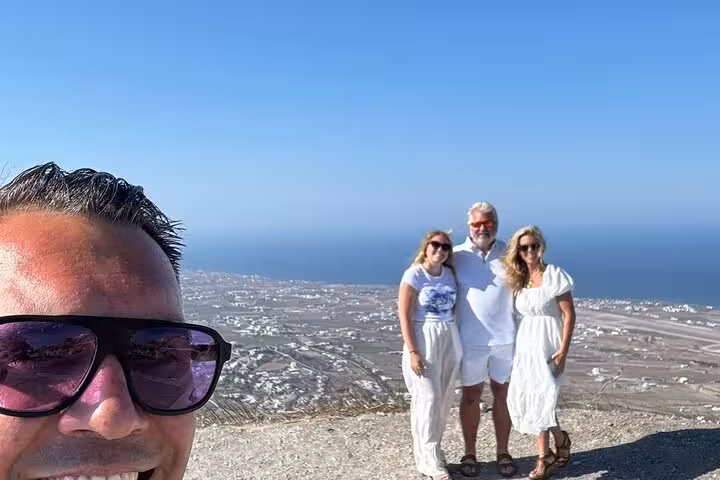 Cruise ship shore excursion in Santorini with travelers at a panoramic hilltop viewpoint over the Aegean Sea