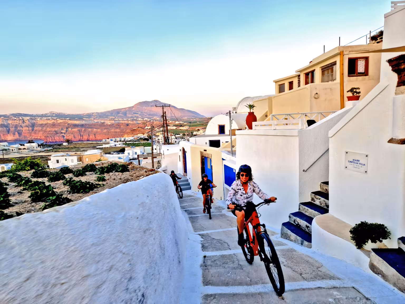 Santorini e-bike tour through whitewashed village steps with caldera views, perfect morning or sunset option