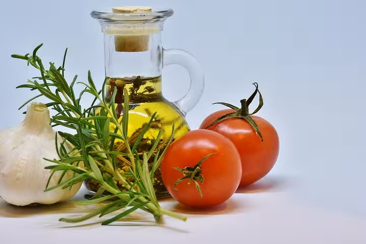 Fresh Greek ingredients for cooking class: olive oil, tomatoes, garlic and rosemary for Santorini caldera-view menu