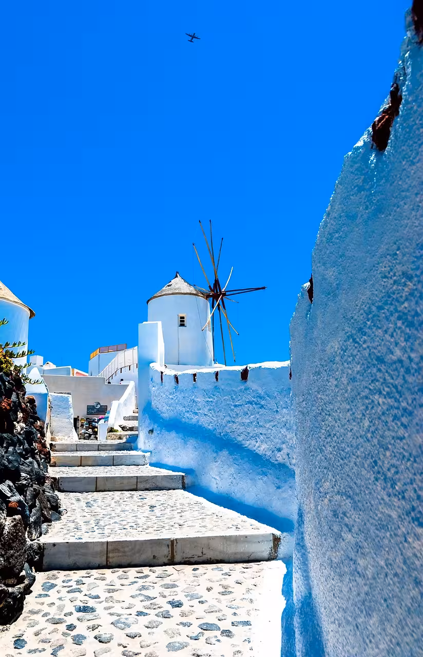 Cobblestone steps to Oia windmill in Santorini, scenic walking route for cruise guests on a 3-hour shore tour