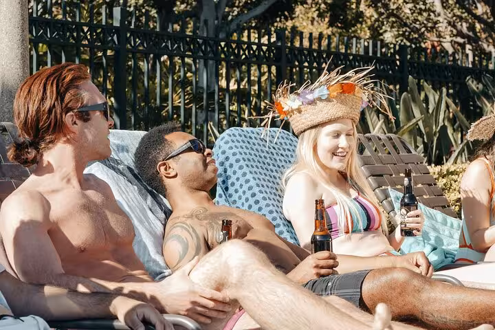 Guests lounge poolside in Santorini with drinks, enjoying a private pool day before caldera sunset views