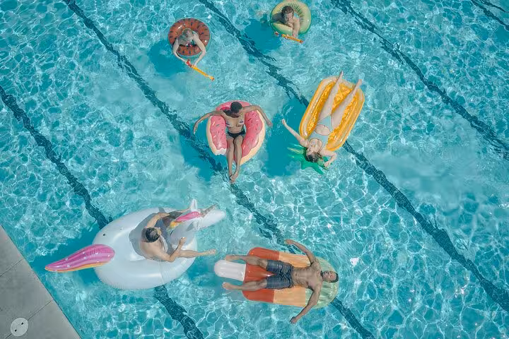 Guests relax on inflatables in a private pool in Santorini, perfect for caldera views and sunset day experience
