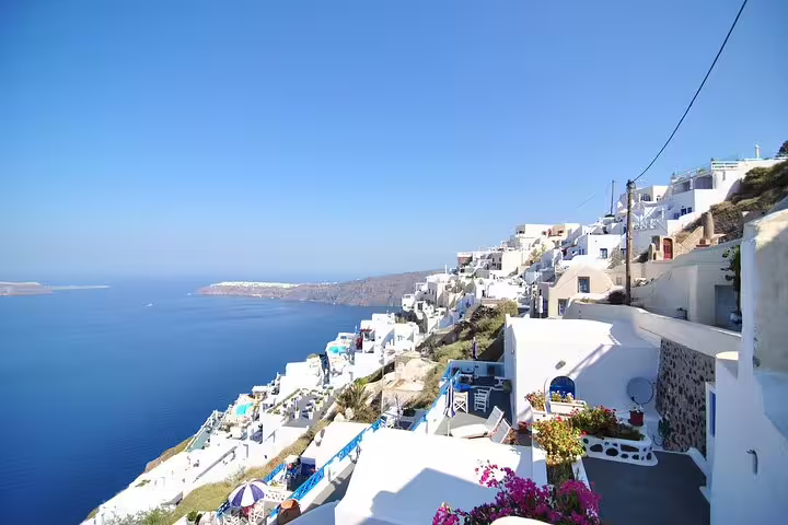 Scenic view of Santorini's iconic white-washed buildings and deep blue Aegean Sea on a private full-day sightseeing tour.