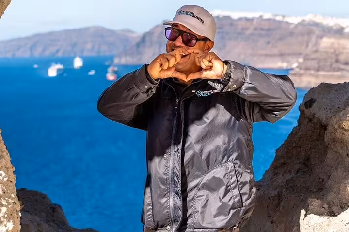 Local guide at Santorini caldera viewpoint during authentic villages tour and farm lunch experience