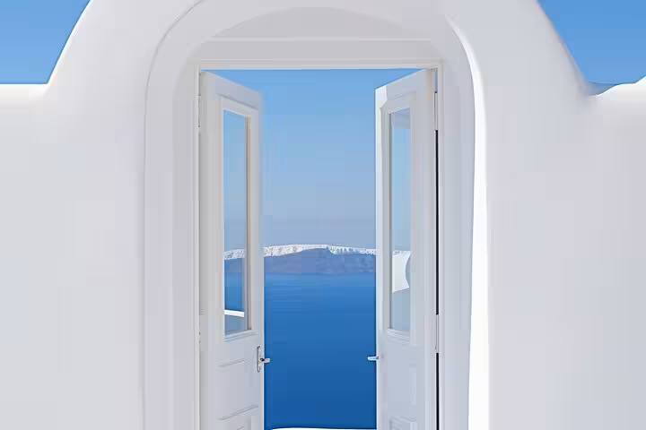 Whitewashed Santorini doorway framing the blue caldera sea, a scenic highlight on a private SUV hidden gems tour
