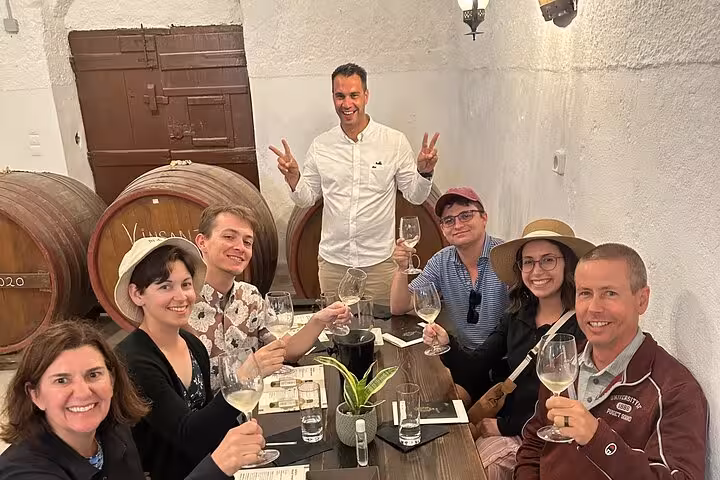 Small group tasting Santorini wines in a traditional winery cellar on a private tour with lunch