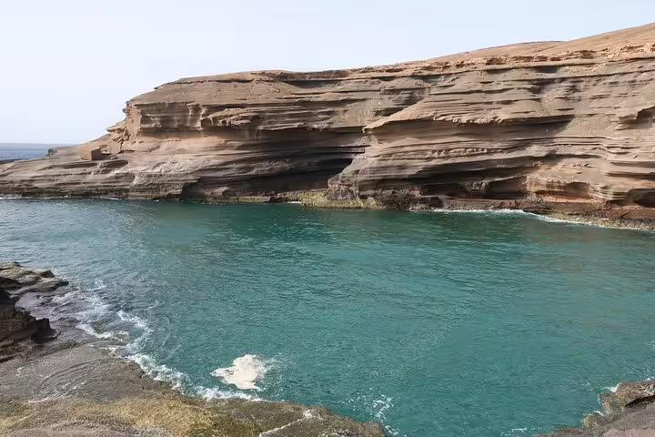 Stunning view of Carbeirinho's natural rocky cliffs and turquoise waters along the São Nicolau hiking trail.